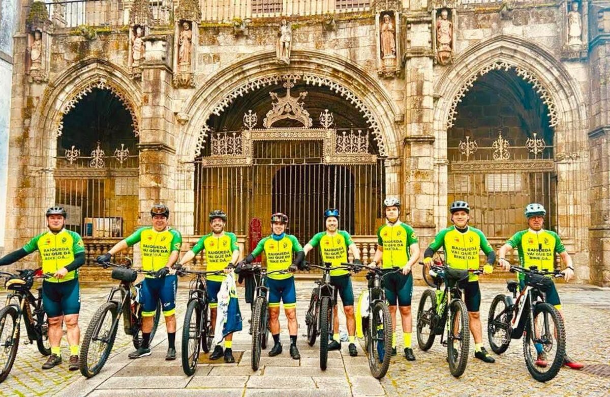 Grupo de ciclistas con sus bicicletas frente a un edificio histórico