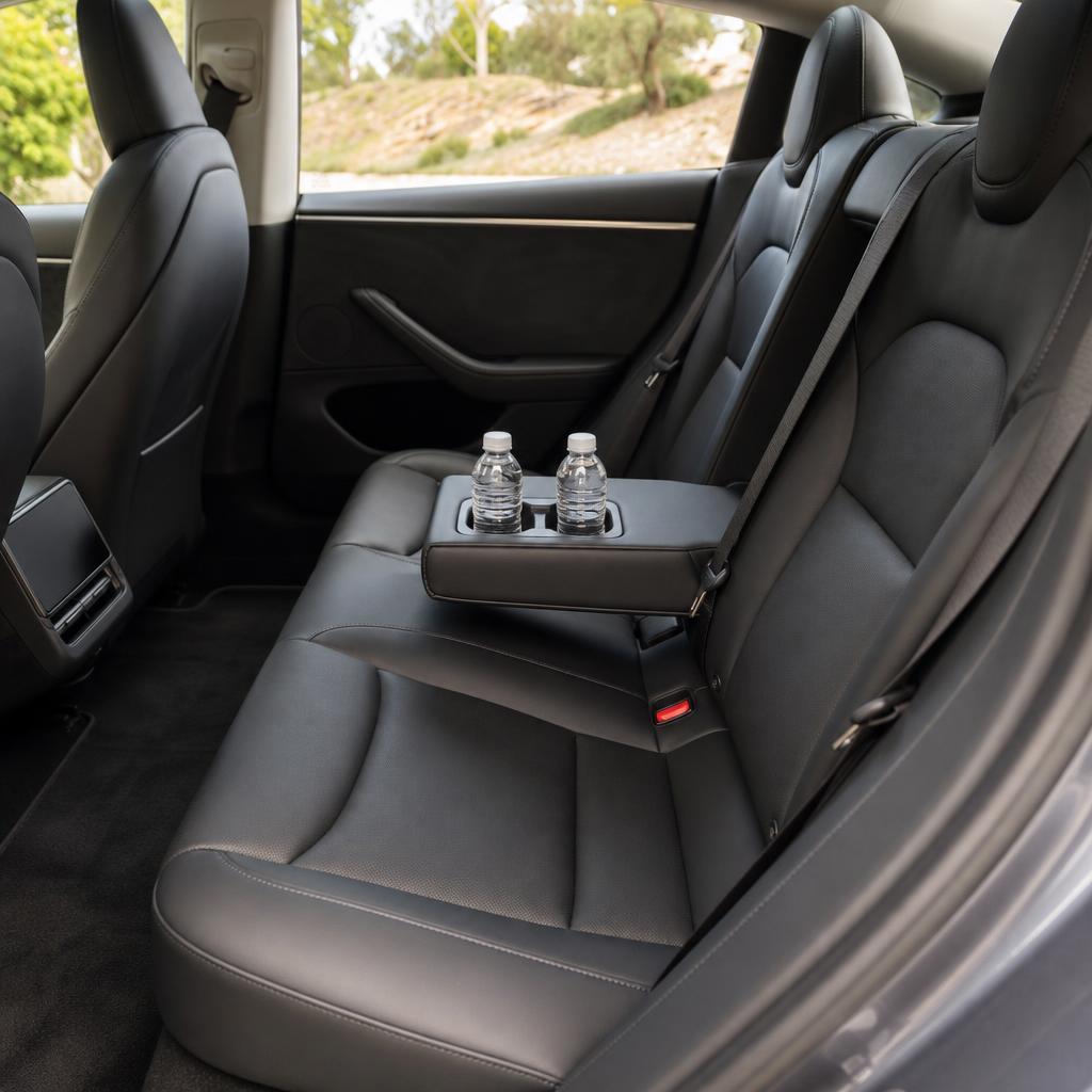 Rear seats of a Tesla Model 3 with the cup holders open and two water bottles