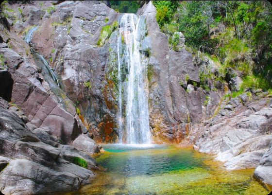 Cascata do Arado falling into a clear green pool